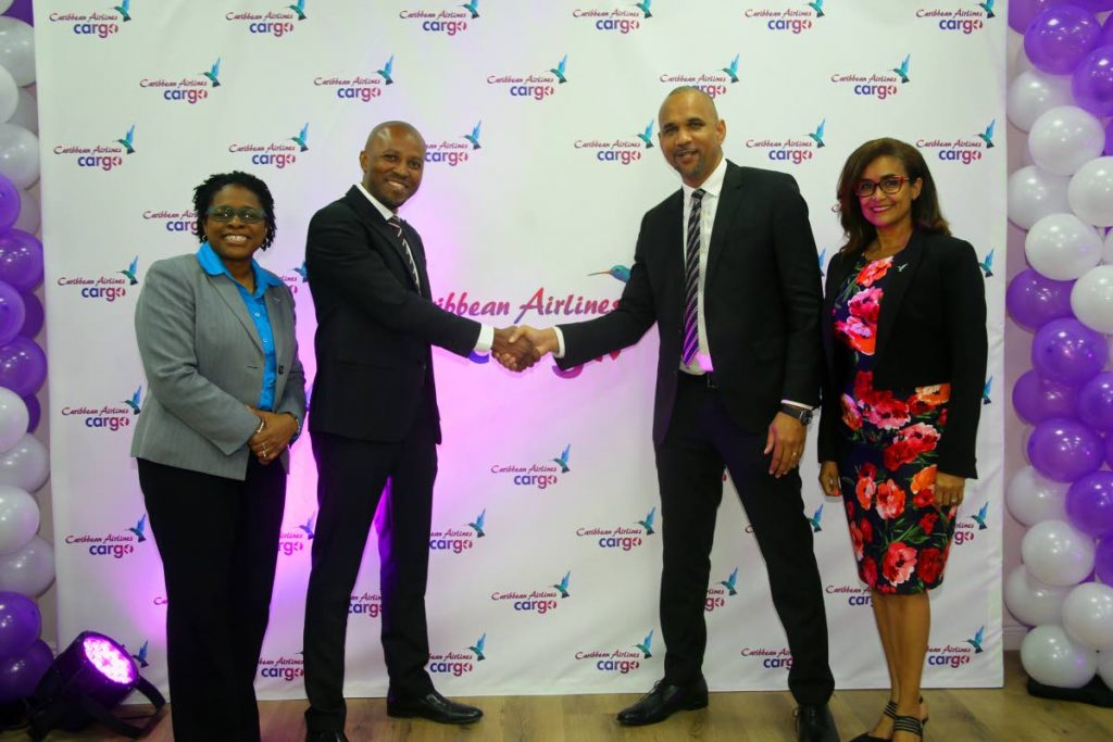 Caribbean Airlines (CAL) recently launched its Cargo Loyalty programme. Shaking hands to celebrate the occasion are CAL CEO Garvin Medera (second from right) and GM Marklan Moseley. At right is CAL executive manager Giselle Laronde-West while at left is corporate communications manager Dionne Ligoure. The event took place at CAL’s Golden Grove office.  - SUREASH CHOLAI