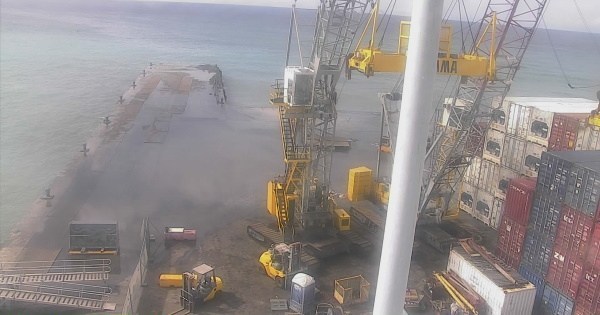 Containers wash off flooded cargo dock