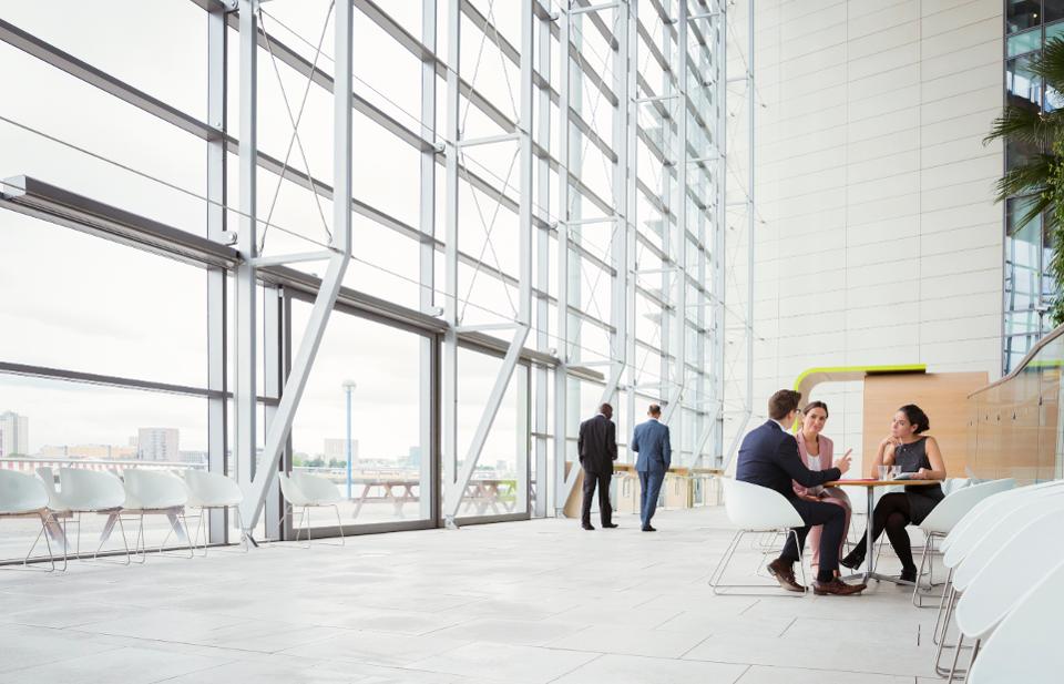 Business people discussing plans in modern lobby