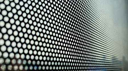 Round holes in a black screen on window.