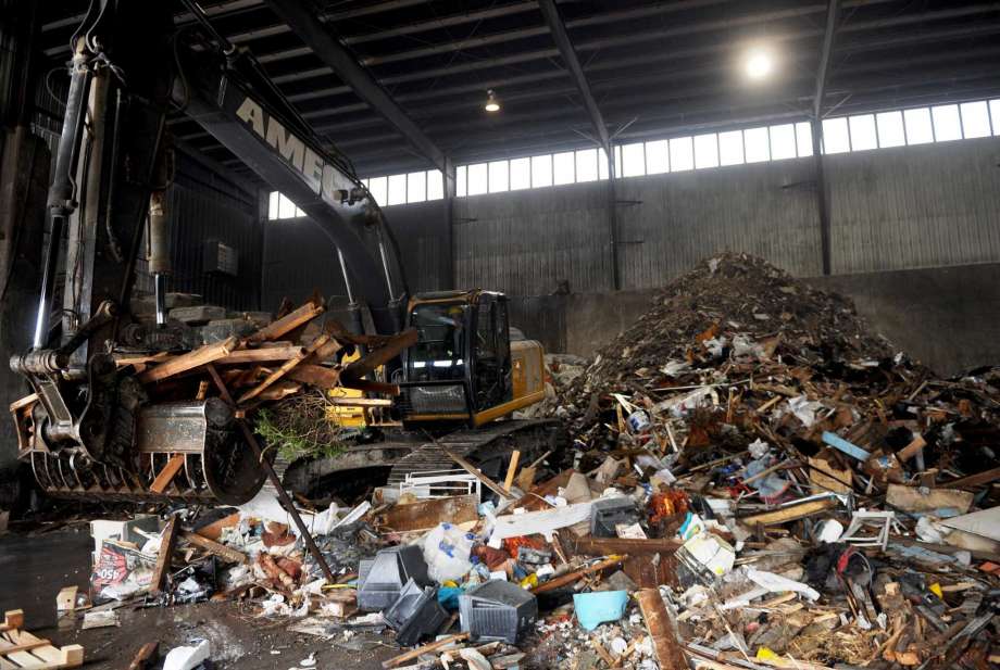 Employees move piles of materials to separate recyclables from trash to be sent to the landfill at AMEC Carting recycling plant in Norwalk. Photo: File Photo / Connecticut Post