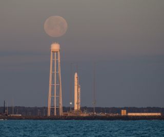 The full moon appears to hover over Pad-0A of NASA's Wallops Flight Facility at dawn on Feb. 9, 2020 where a Northrop Grumman Antares rocket and Cygnus cargo ship stood ready for a launch attempt to the International Space Station.