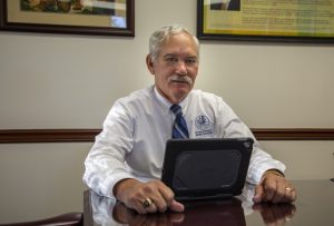 Delaware Secretary of Agriculture Michael T. Scuse seated with computer