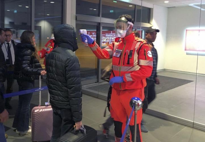 Italian officials vet passengers at Bologna airport.