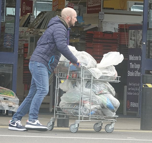 A shopper wheels several bags of compost of the store earlier today